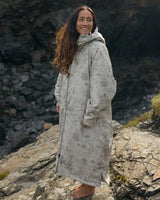 Lead_women - Woman wearing a Vivida sherpa weatherproof changing robe Desert Sand by a lake